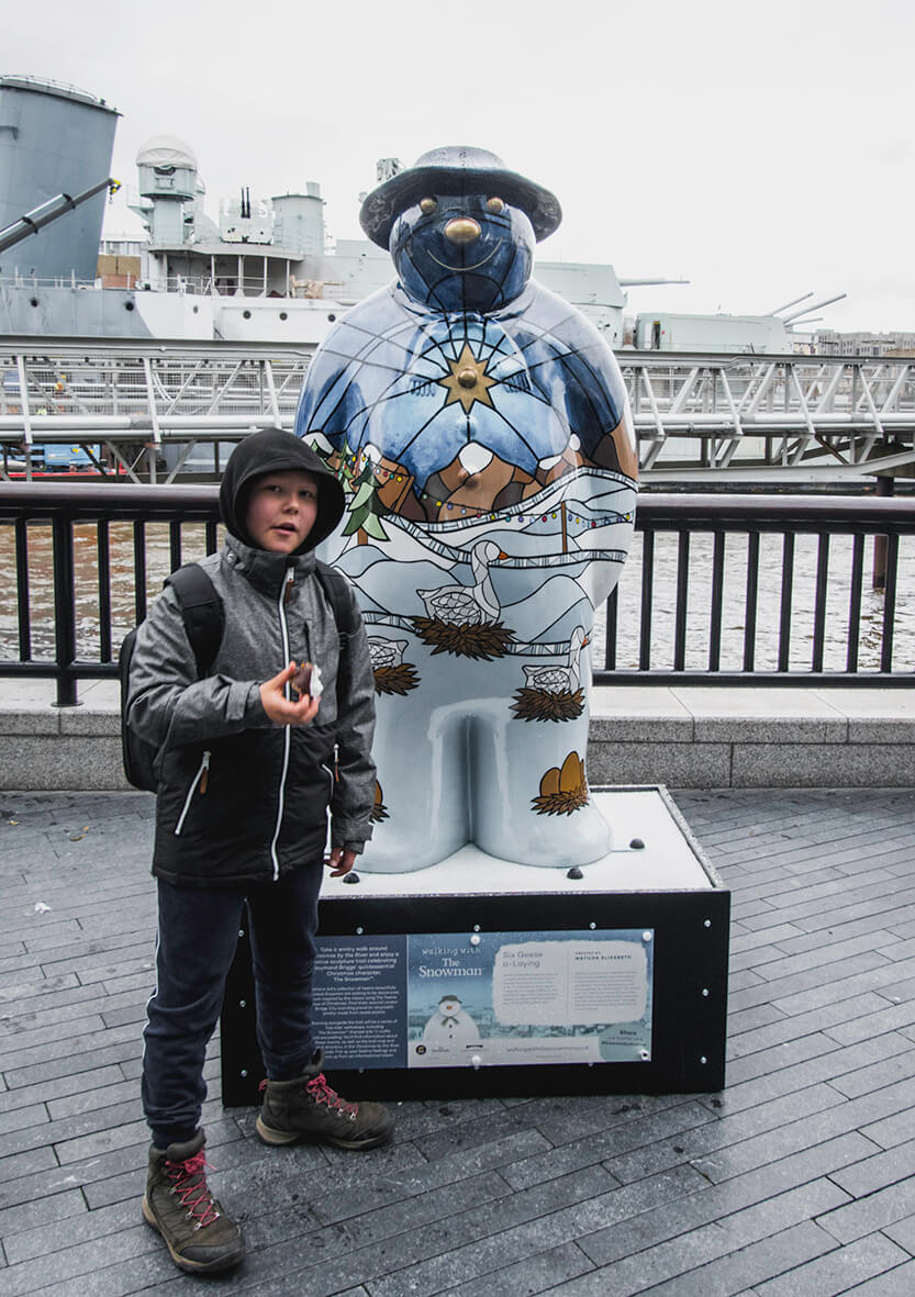 Sebastian with a Raymond Briggs “Snowman” figure near Tower Bridge in London.